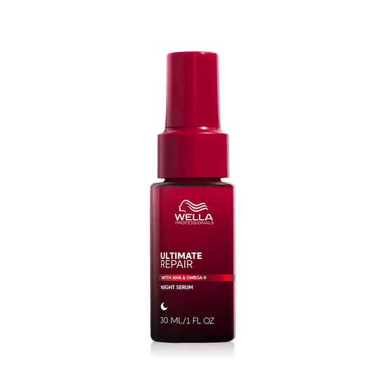 Close-up of Wella Ultimate Repair Night Serum bottle on a soft fabric background