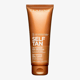 Bottle of clarins self tanning milky lotion on a white background